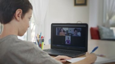 COVID-19 tecridi sırasında online derse katılan genç bir çocuk.