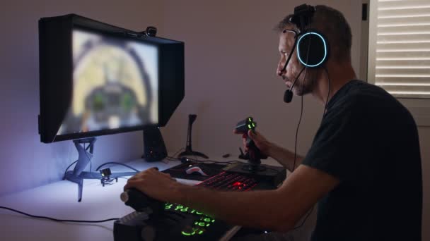 Hombre jugando un simulador de vuelo en el ordenador, usando un auricular — Vídeo de stock