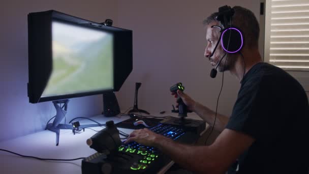Hombre jugando un simulador de vuelo en el ordenador, usando un auricular — Vídeo de stock