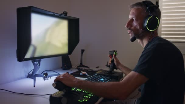 Bilgisayarda uçuş simülatörü çalan, kulaklık takan bir adam. — Stok video