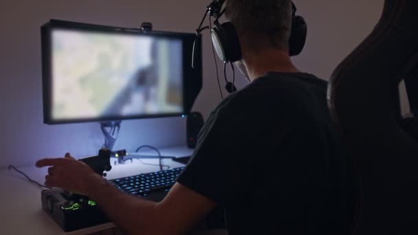 Hombre jugando un simulador de vuelo en el ordenador, usando un auricular — Vídeos de Stock