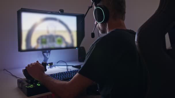 Mannen som spelar en flygsimulator på datorn, med ett headset — Stockvideo