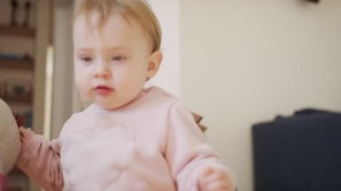 Evde oynayan sevimli bir bebek ve kameraya gülümsüyor.