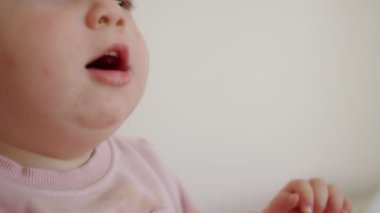 Evde oynayan sevimli bir bebek ve kameraya gülümsüyor.