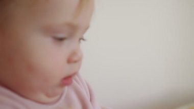 Evde oynayan sevimli bir bebek ve kameraya gülümsüyor.