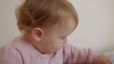 Evde oynayan sevimli bir bebek ve kameraya gülümsüyor.
