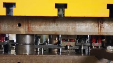 Üretim hattında metal parçaları oluşturan bir punç presinin kapanışı