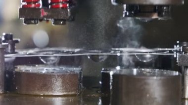 Üretim hattında metal parçaları oluşturan bir punç presinin kapanışı