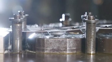 Üretim hattında metal parçaları oluşturan bir punç presinin kapanışı