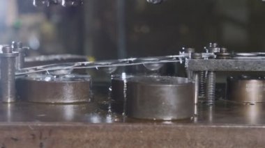 Üretim hattında metal parçaları oluşturan bir punç presinin kapanışı