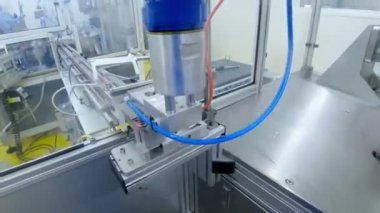 Bir imalat tesisinde robot hattı. Robot metal parçaları yerleştiriyor