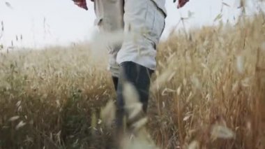 Yüksek çizmeler giyen bir adamın yoğun bitki örtüsünde yürümesi.