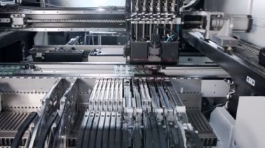 SMT makinesi rezistörler, kapasitörler, transistörler, LED ve entegre devreleri yüksek hızda devre kartlarına yerleştirir