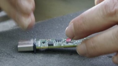 PCB panosundaki elektronik bileşenlerin elle lehimlenmesi.