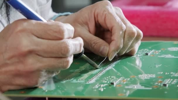 Handmatig solderen van elektronische componenten op een printplaat, close-up — Stockvideo