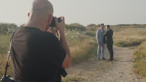 Fotograf robi zdjęcia gejowskiej parze przed ślubem na plaży — Wideo stockowe