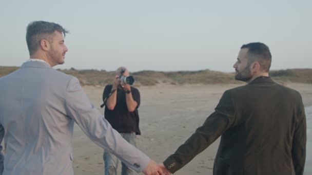 Photographe prenant des photos de couple gay avant leur mariage sur la plage — Video
