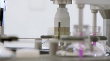 Otomatik ilaç üretim hattı, sıvıyla dolu şişeler.