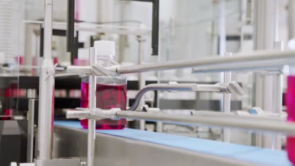 Automated pharmaceutical manufacturing line, bottles filled with liquid — Stock Video