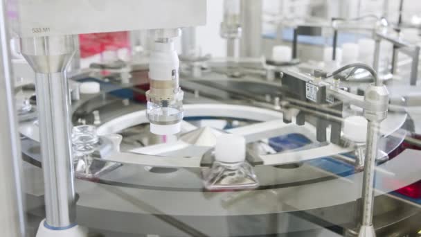 Automated pharmaceutical manufacturing line, bottles filled with liquid — Stock Video