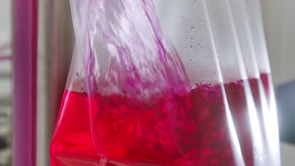 Piros folyadékkal teli műanyag zacskók a gyógyszergyártó tisztaszobában — Stock videók