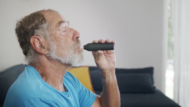 Человек с болезнью Паркинсона, использующий медицинскую марихуану в испарителе, чтобы перестать дрожать — стоковое видео