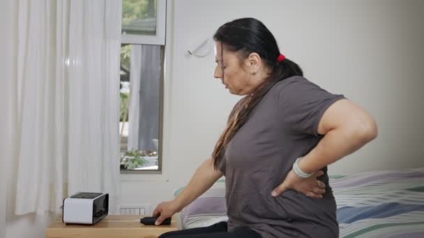 Kobieta z ciężkim bólem pleców używa marihuany medycznej z odparowywaczem dla ulgi — Wideo stockowe