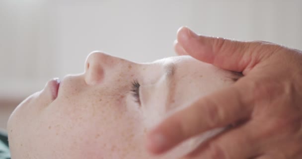 Shiatsu treatment. Masseuse giving a gentle face massage to a young boy — Vídeo de stock