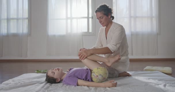 Shiatsu treatment. Masseuse giving treatment to a young girl, using different methods. — Stock Video