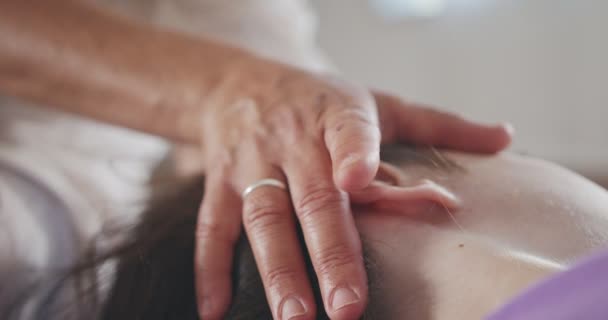 Shiatsu-Behandlung. Masseurin gibt einem kleinen Mädchen sanfte Gesichtsbehandlung — Stockvideo