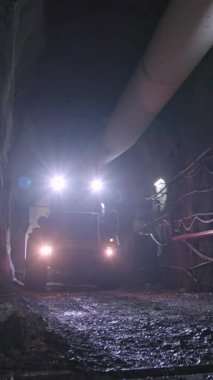 Tünelin içinde büyük inşaat kamyonları var.