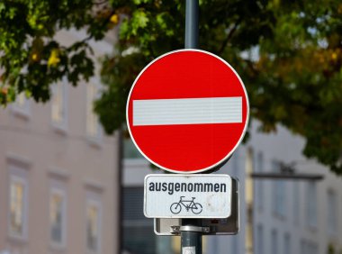 No entry sign with bicycle exception on urban street.