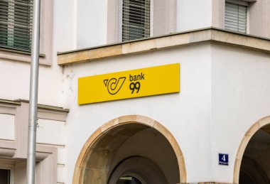 Klagenfurt, Austria - October 04, 2025: Bank 99 storefront displays vibrant yellow sign in urban environment, highlighting modern architecture and financial services