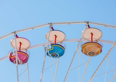 Vibrant ferris wheel against clear blue sky on a sunny day.