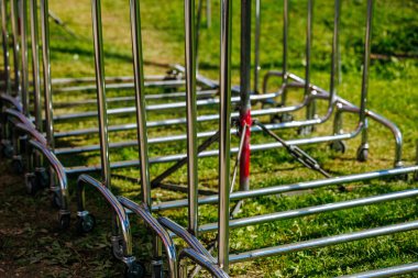Metallic shopping cart frames on green grass outdoors.