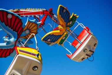 St Veit An Der Glan, Austria - October 03, 2025: Amusement park ride at St. Veiter Wiesenmarkt features bright colors and thrilling design against a clear blue sky