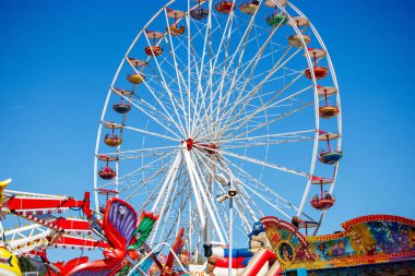 St Veit An Der Glan, Austria - October 03, 2025: Bright Ferris wheel at St. Veiter Wiesenmarkt, with carnival rides and clear sky creating joyful ambiance