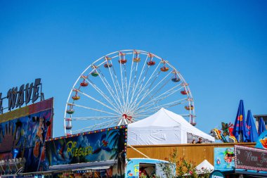 St Veit An Der Glan, Austria - October 03, 2025: St. Veiter Wiesenmarkt displays a lively Ferris wheel under bright blue sky, surrounded by colorful fair attractions