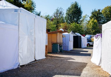 St Veit An Der Glan, Austria - October 03, 2025: St. Veiter Wiesenmarkt features white tents along a pathway, creating a lively outdoor market environment