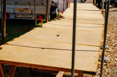 St Veit An Der Glan, Austria - October 03, 2025: Wooden tables at St. Veiter Wiesenmarkt, ready for vendors, creating a lively market scene filled with colors and energy