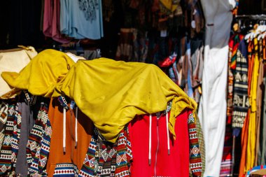 St Veit An Der Glan, Austria - October 03, 2025: Colorful clothing items covered with yellow fabric at St. Veiter Wiesenmarkt, highlighting local fashion and vibrant market life