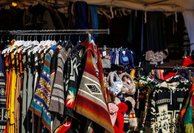 St Veit An Der Glan, Austria - October 03, 2025: Handcrafted garments and textiles are beautifully arranged at St. Veiter Wiesenmarkt, highlighting vibrant colors and patterns with copy space