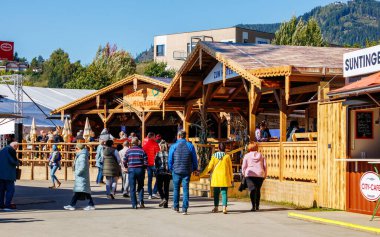 St Veit An Der Glan, Austria - October 03, 2025: St. Veiter Wiesenmarkt features lively crowds exploring wooden stalls, highlighting local traditions and community engagement