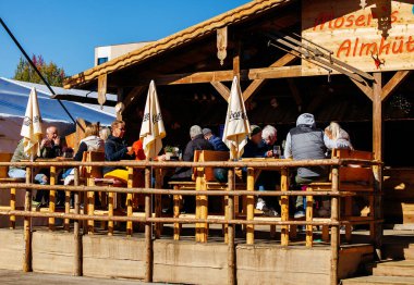 St Veit An Der Glan, Austria - October 03, 2025: Outdoor dining at St. Veiter Wiesenmarkt features people enjoying meals at a rustic wooden restaurant