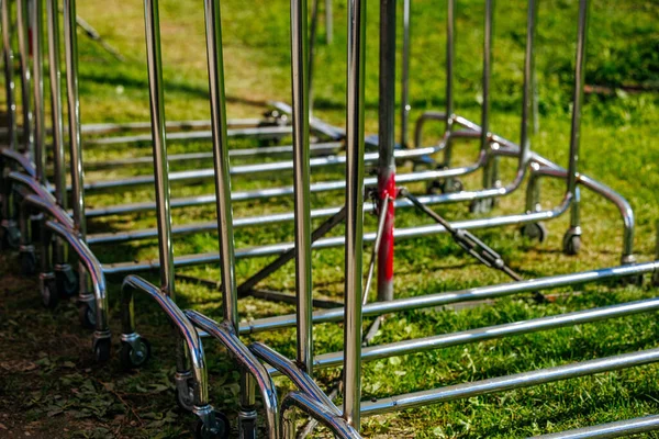 Metallic shopping cart frames on green grass outdoors.