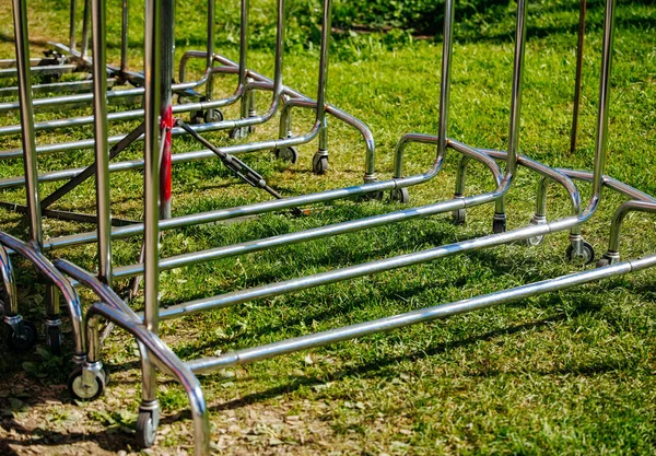 Metal bicycle racks on grass in park.