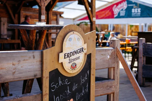 St Veit An Der Glan, Austria - October 03, 2025: Erdinger beer sign featured at St. Veiter Wiesenmarkt, highlighting lively outdoor setting with wooden tables