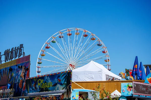 St Veit An Der Glan, Austria - October 03, 2025: St. Veiter Wiesenmarkt displays a lively Ferris wheel under bright blue sky, surrounded by colorful fair attractions