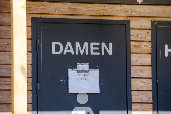 St Veit An Der Glan, Austria - October 03, 2025: Damen restroom door at St. Veiter Wiesenmarkt, showcasing wooden texture and fee notice, enhancing festival experience