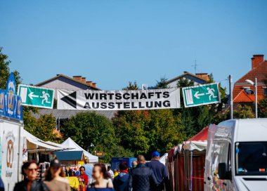 St Veit An Der Glan, Austria - October 03, 2025: St. Veiter Wiesenmarkt features colorful stalls and a prominent Wirtschafts-Ausstellung banner, creating a lively fair atmosphere